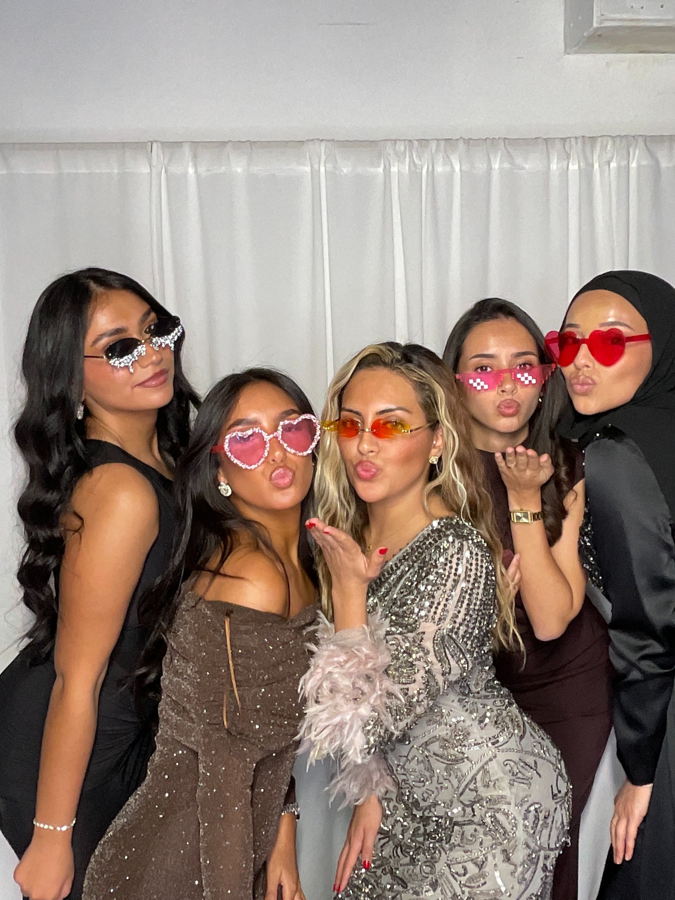 Amies posant avec des lunettes fantaisie au mariage